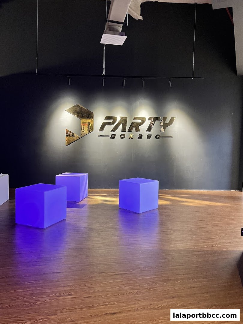 The PartyBox 360 logo is displayed on a black wall with illuminated cubes.