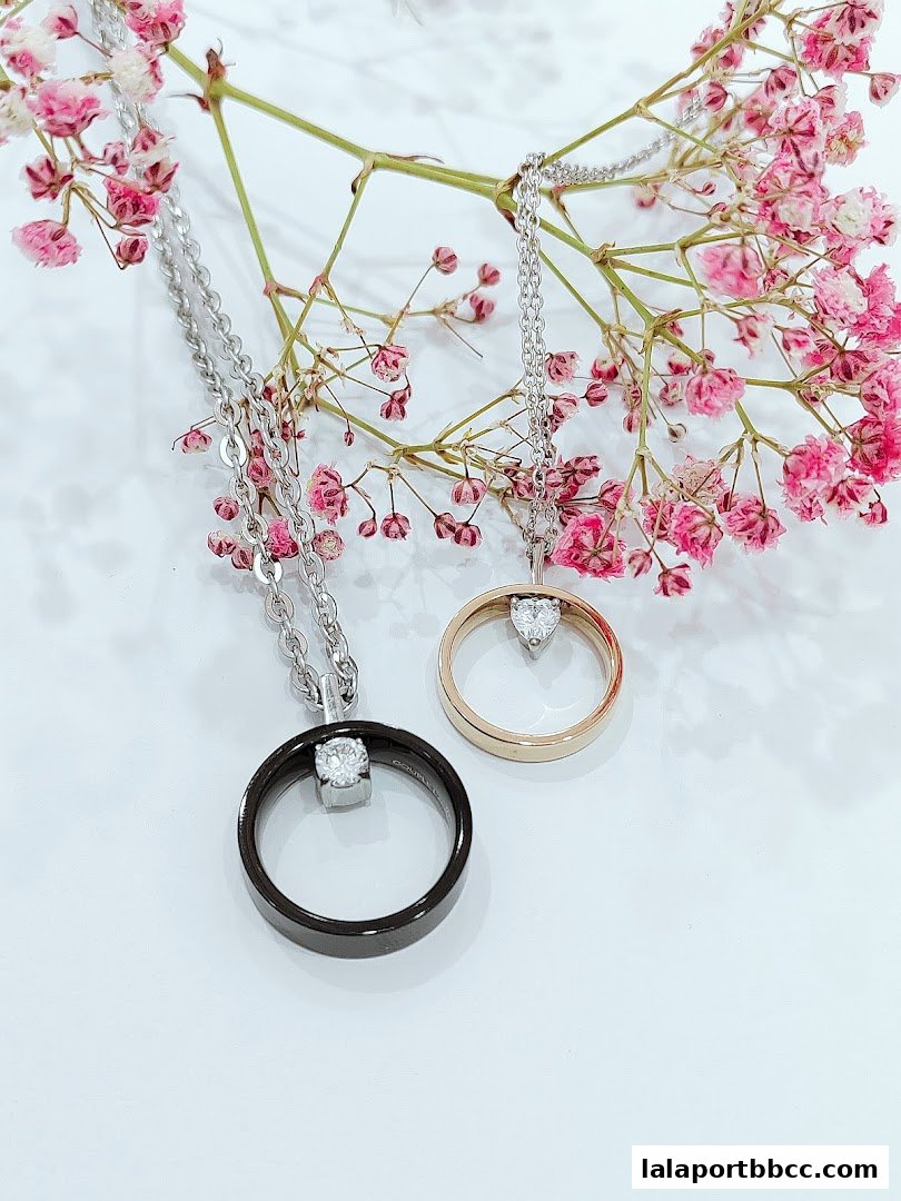 Two elegant necklaces with circular pendants and sparkling stones, adorned with delicate pink flowers.