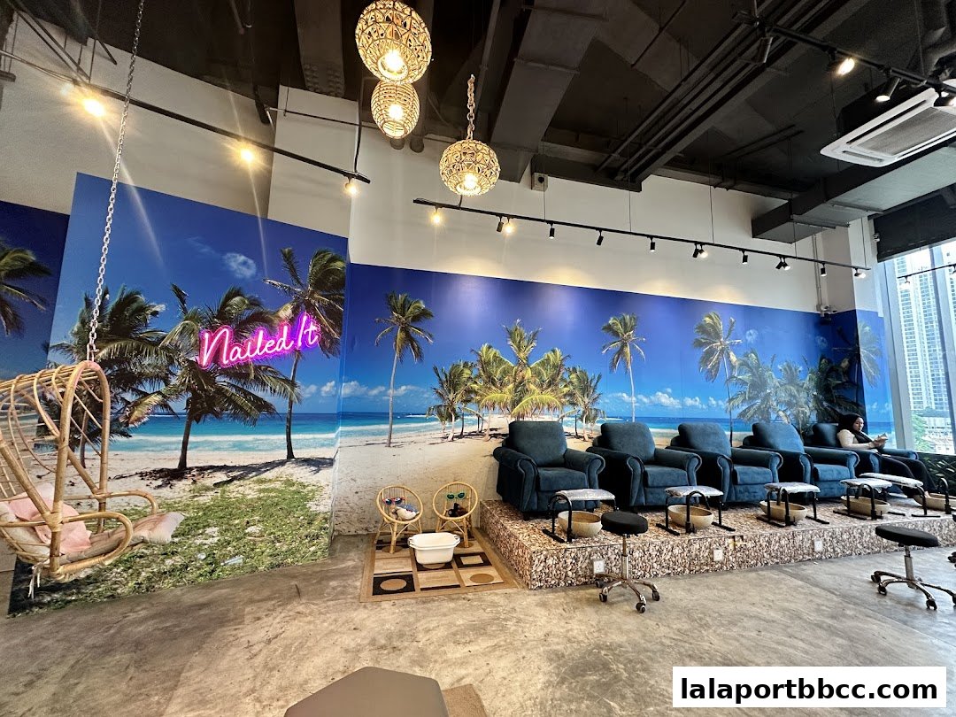 Interior of a nail salon with beach-themed decor and pedicure chairs.