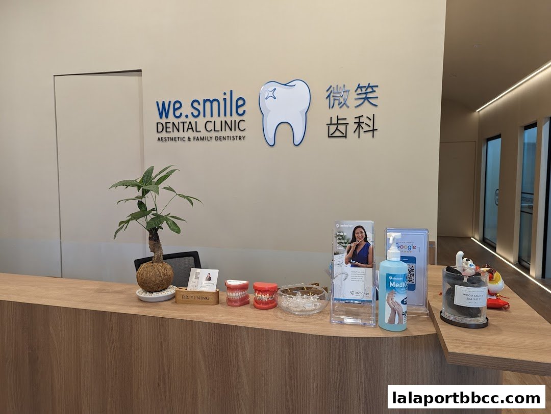 The reception area of WeSmile Dental Clinic, featuring a wooden counter with dental models and branding.