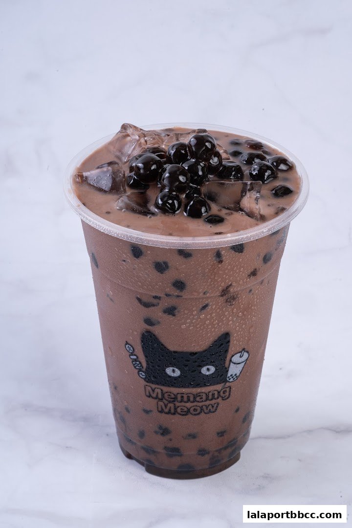 A close-up of a chocolate bubble tea with tapioca pearls and ice.