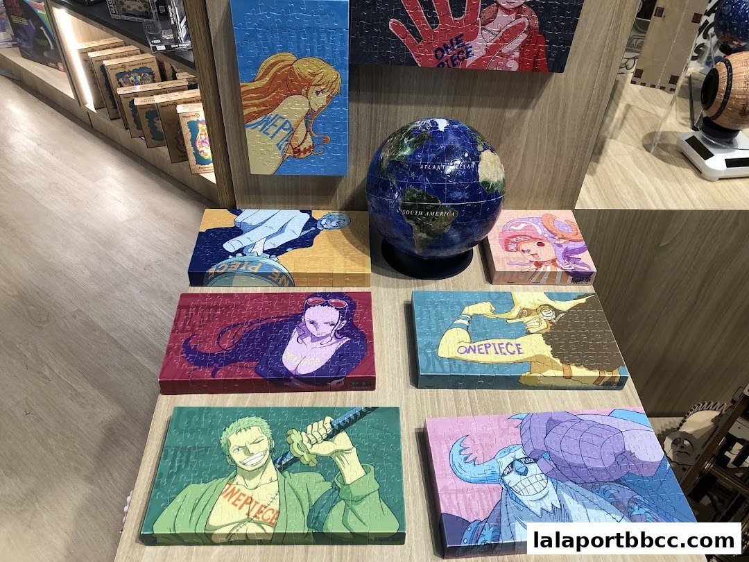 A display of One Piece themed jigsaw puzzles and a globe in a retail store.