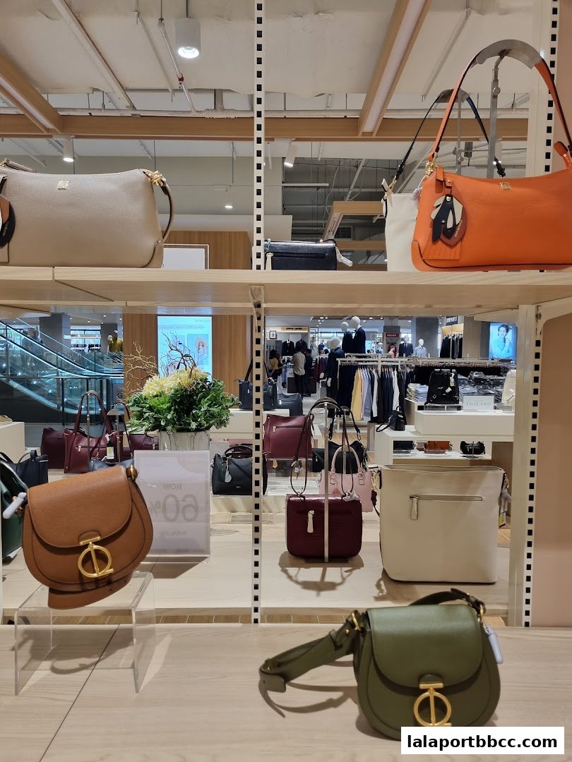 A display of various handbags in different colors and styles on shelves.