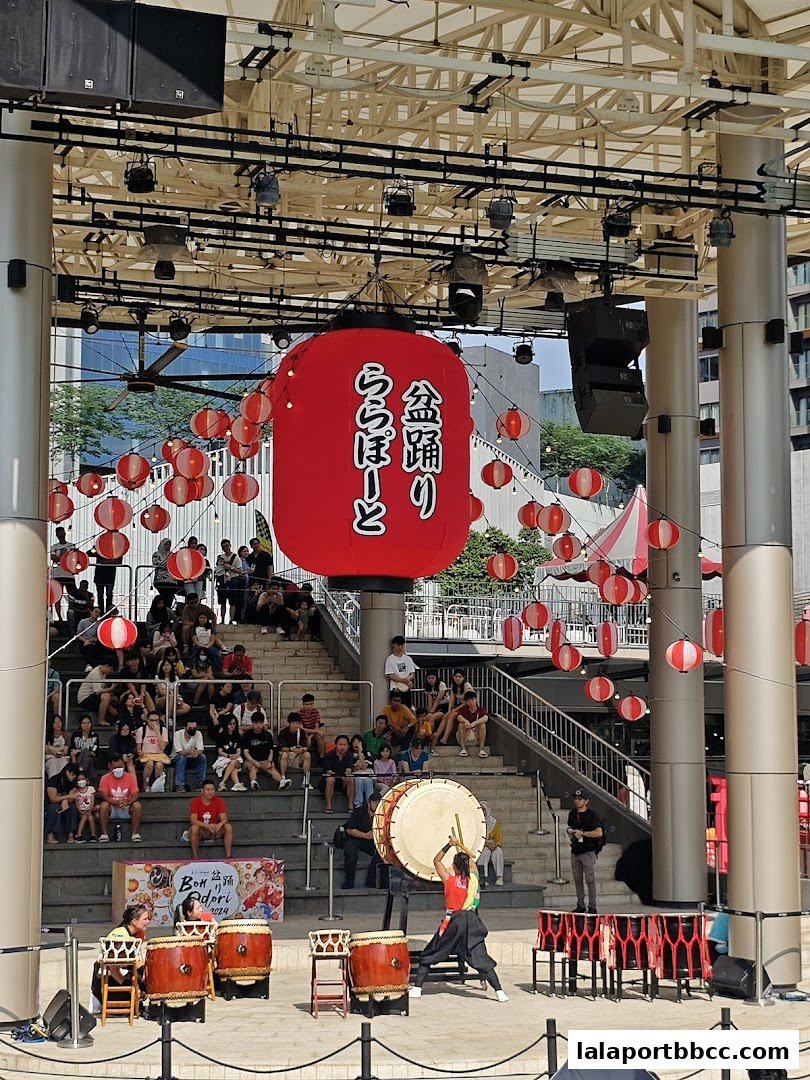 A Japanese drumming performance with a large red lantern and audience watching.