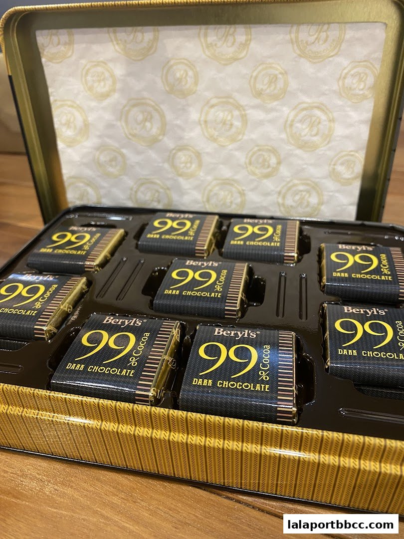 A tin box filled with individually wrapped Beryl's 99% Dark Chocolate squares.