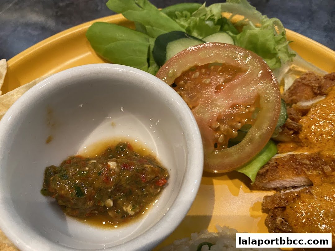 A close-up of a delicious meal featuring crispy chicken, fresh salad, and a side of dipping sauce.