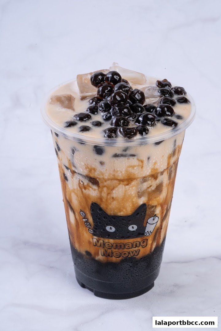 A close-up of a brown sugar bubble tea with ice and tapioca pearls.