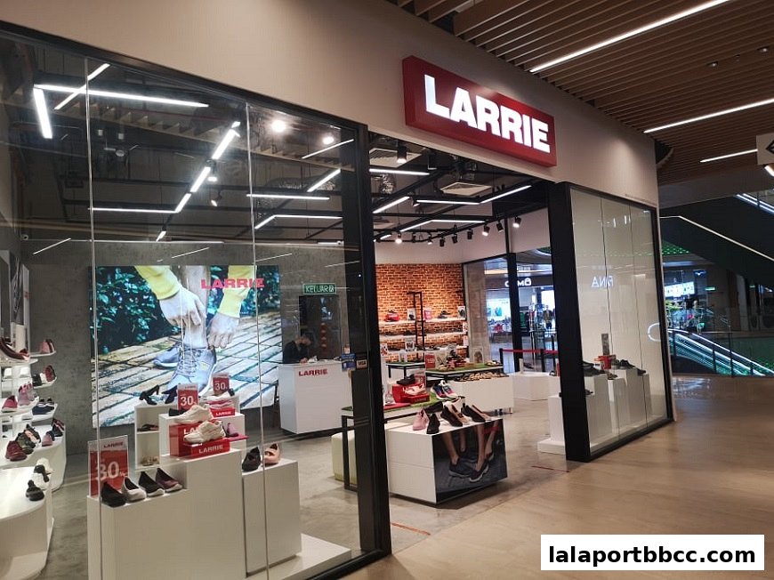 The entrance of a modern shoe store, Larrie, showcasing various footwear and a promotional display.