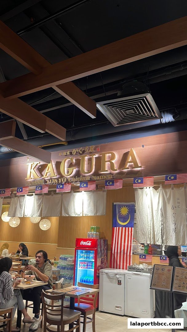 Interior of Kagura Tokyo Chicken Ramen with diners and a prominent sign.