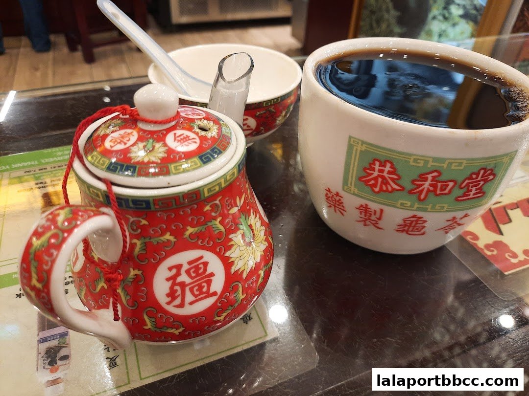 A traditional Chinese herbal tea set with a teapot and cup on a table.