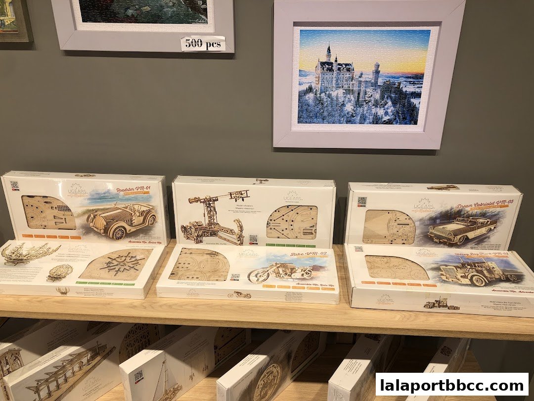 Wooden mechanical model kits displayed on shelves, including cars and a motorcycle.