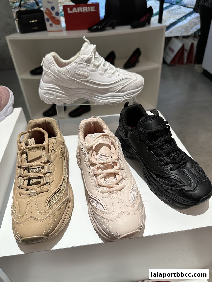 A display of Larrie brand sneakers in white, beige, and black.