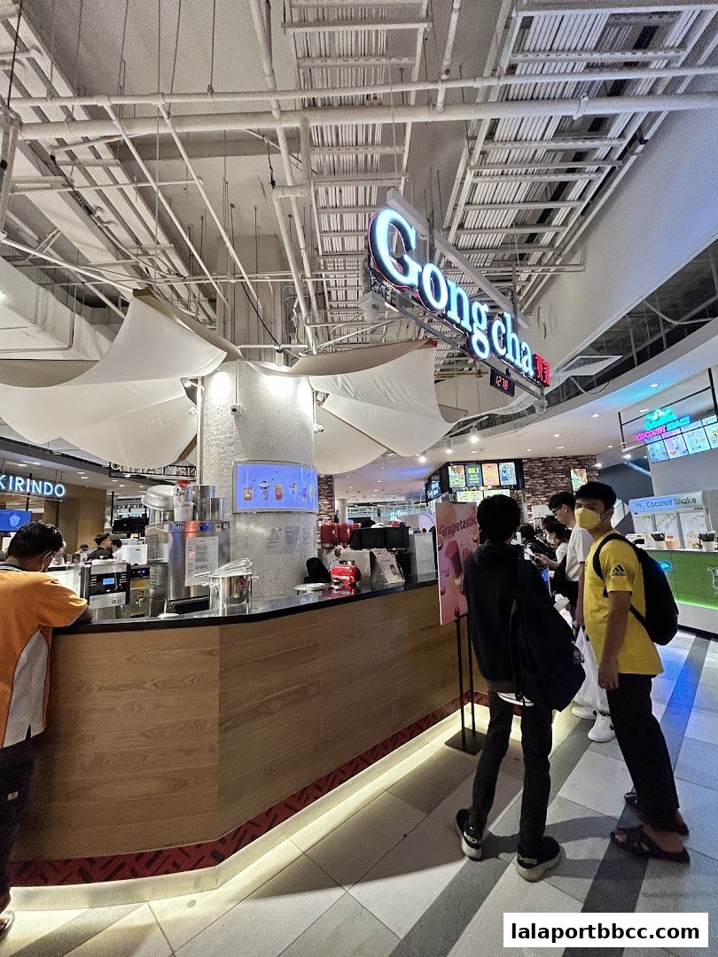 A Gong Cha bubble tea shop counter with customers waiting in line.