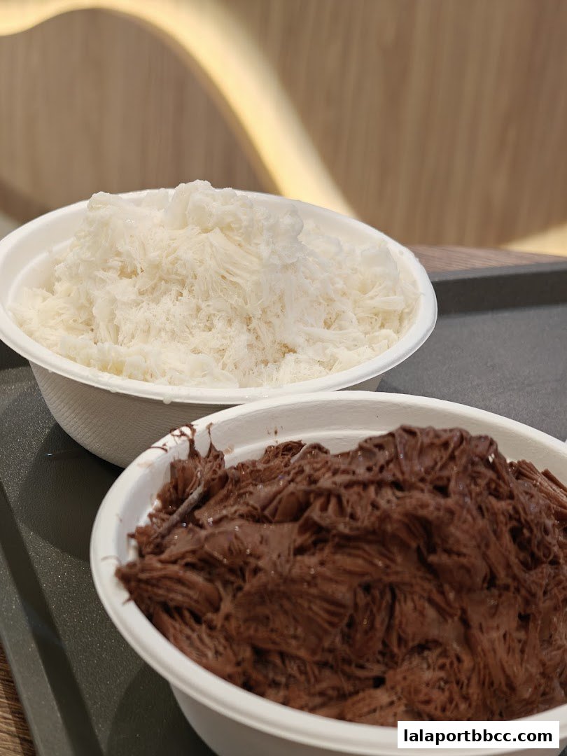 Two bowls of shaved ice, one white and one chocolate flavored, are presented.