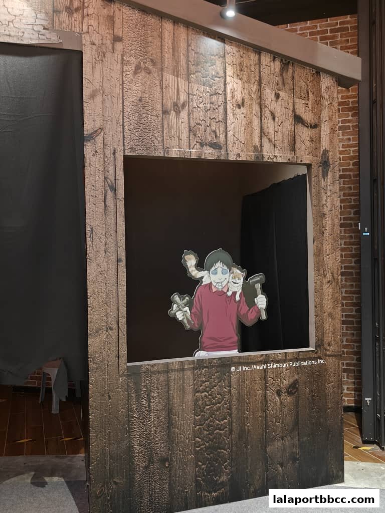 A wooden booth with a cutout featuring a character from Junji Ito's horror manga.