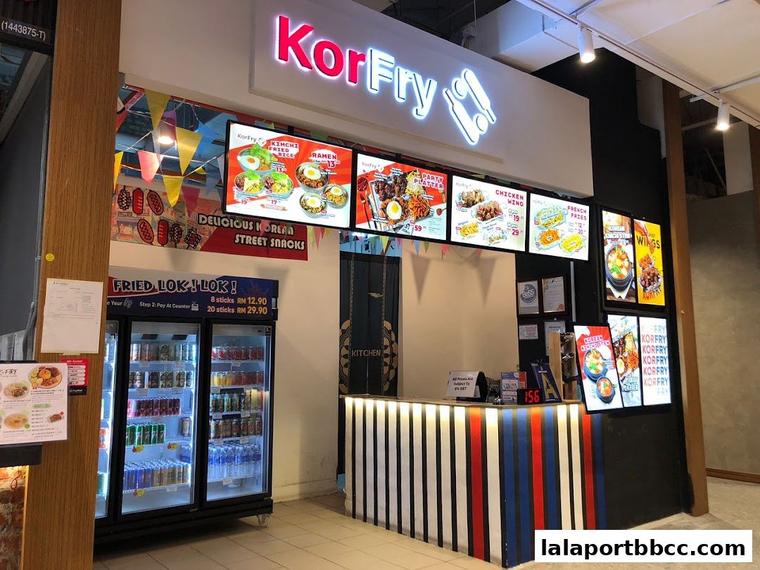 A KorFry Korean street food stall with illuminated menu boards and a display fridge.