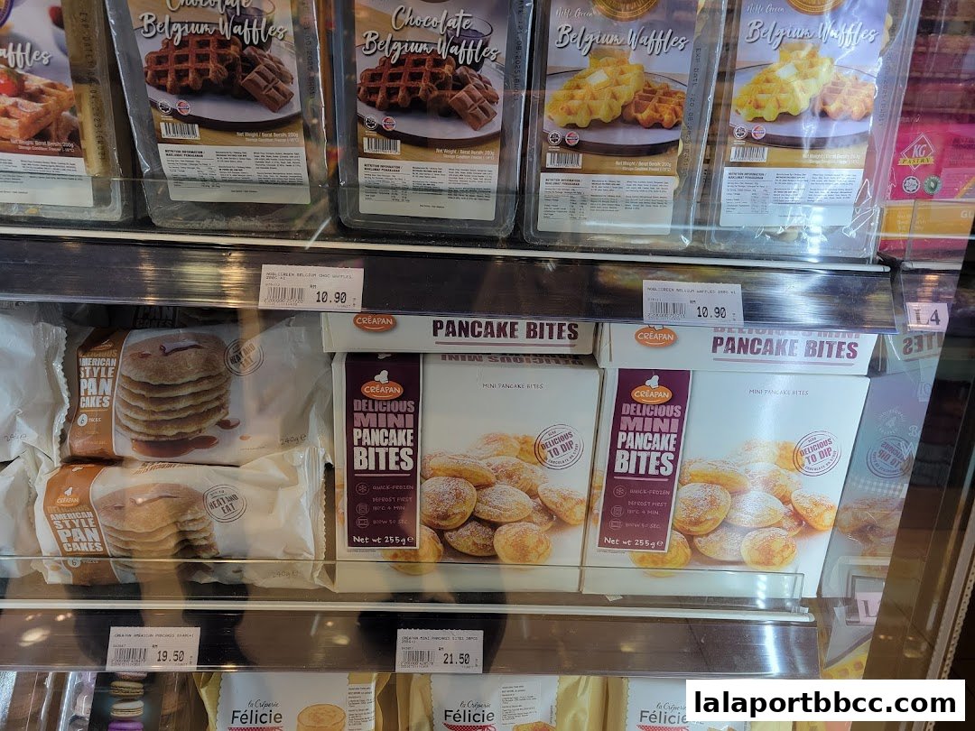 A refrigerated display case filled with various frozen waffles and pancake products.
