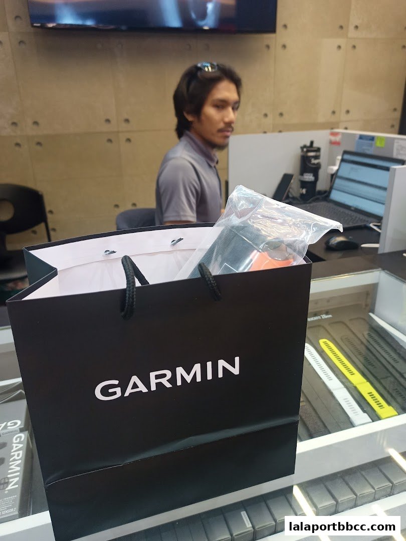 A black Garmin shopping bag with a purchase inside, in front of a store counter.