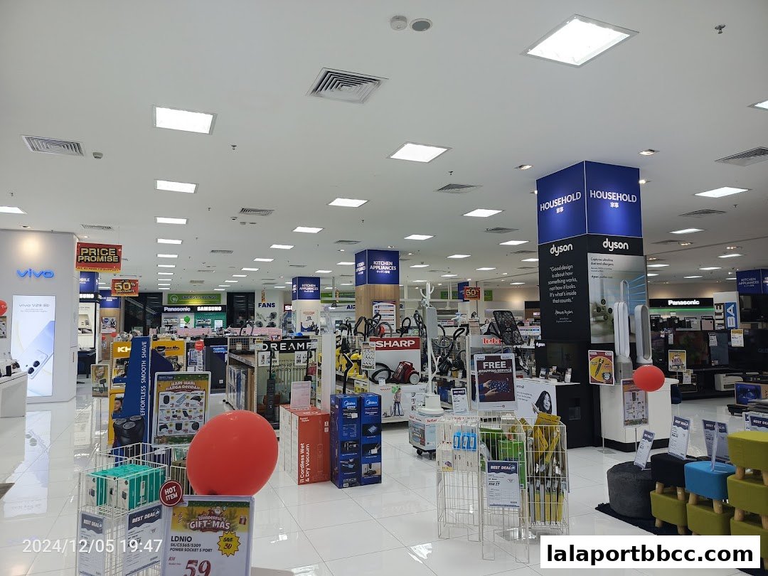 Interior view of a well-lit electronics and home appliance store with various products on display.