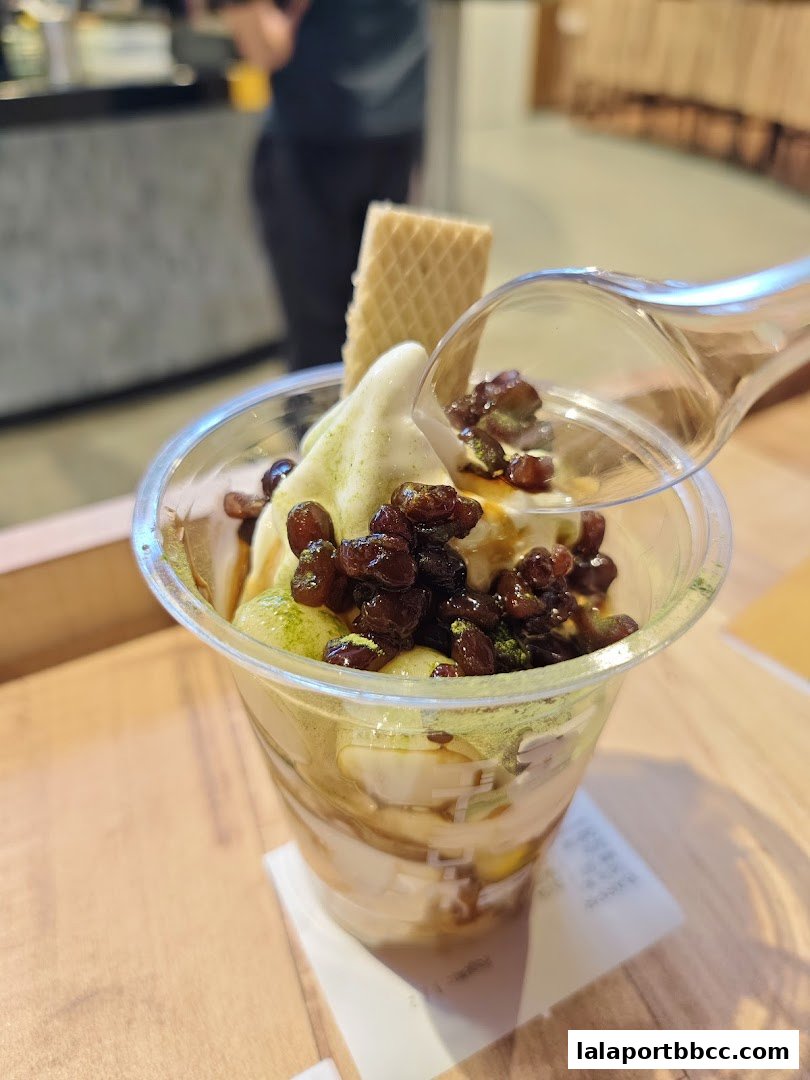 A delicious parfait with soft serve ice cream, red beans, and a wafer.