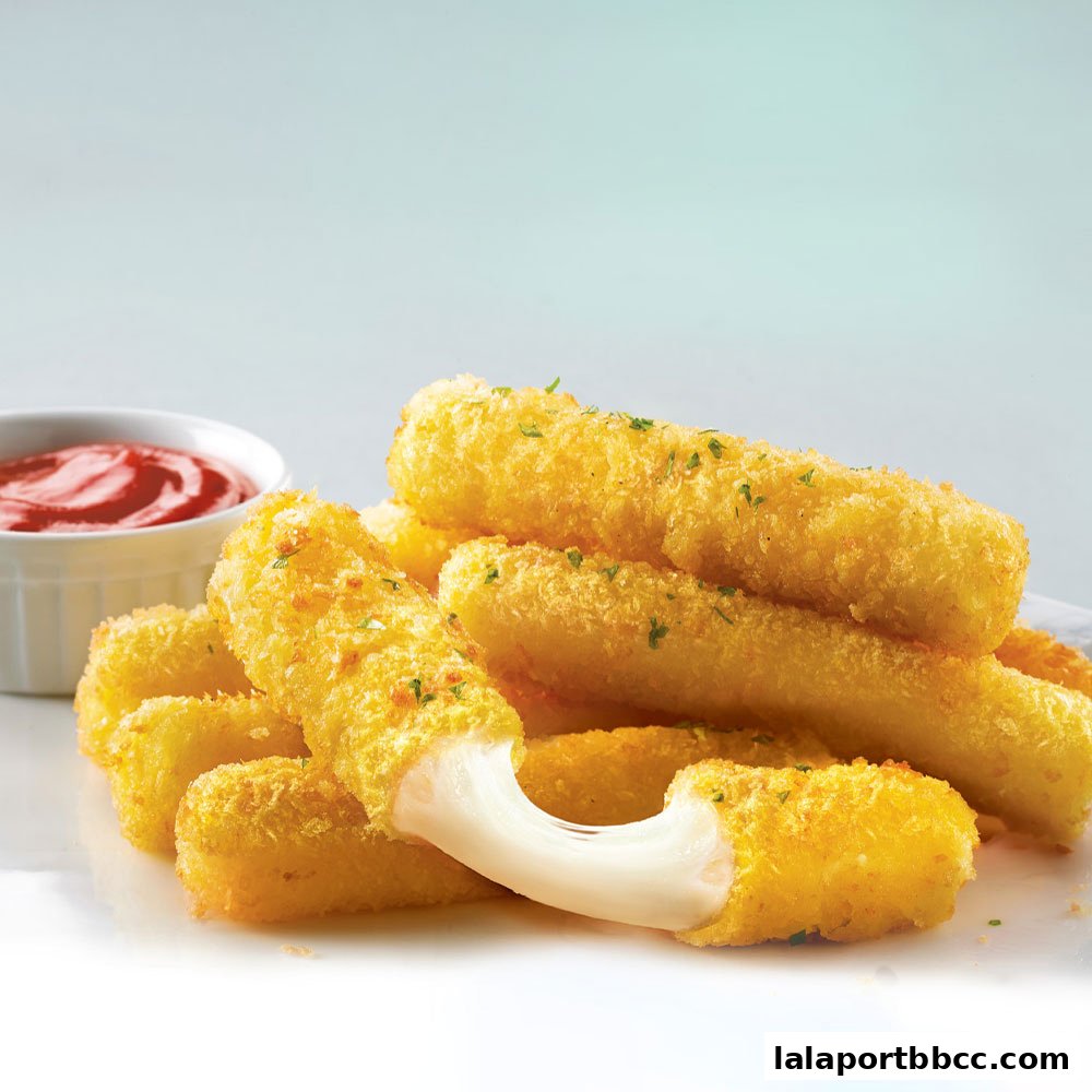 Golden fried mozzarella sticks with a side of ketchup on a white plate.