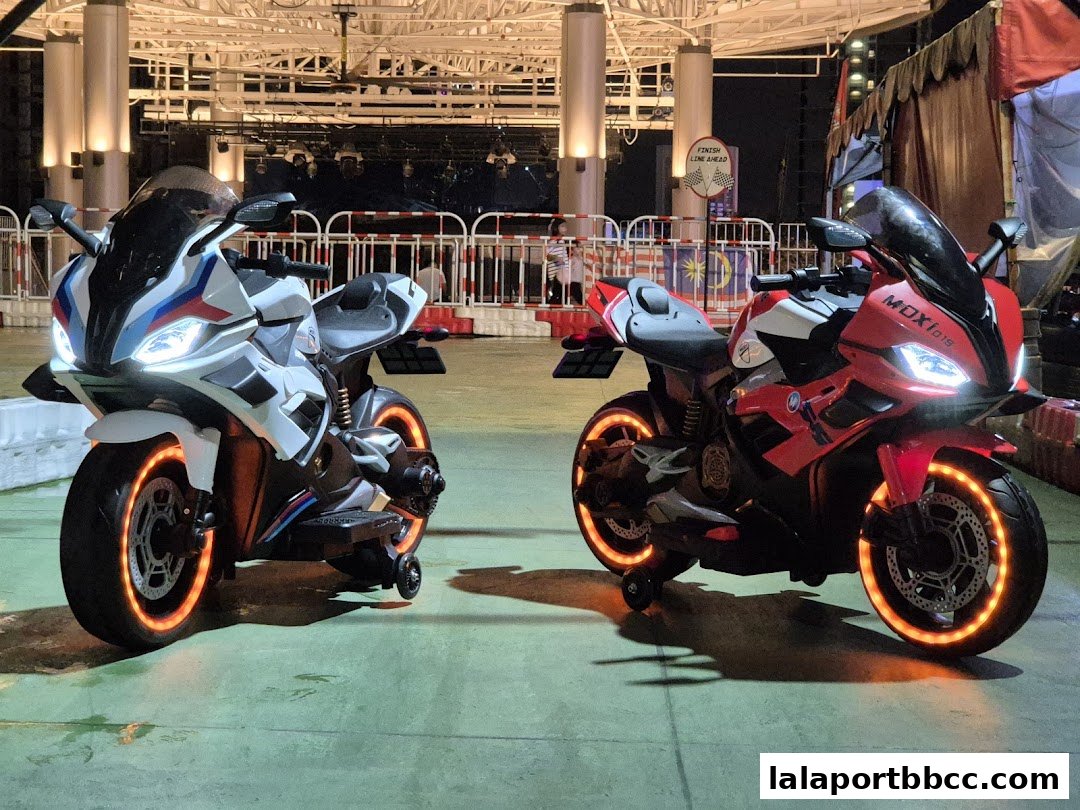 Two electric ride-on motorcycles, one white and one red, with illuminated wheels.
