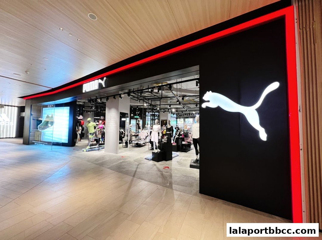 The modern PUMA store entrance features a large illuminated logo and mannequins displaying athletic wear.