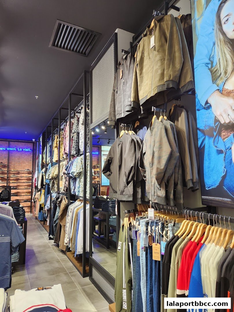 Interior view of a clothing store showcasing a variety of men's apparel on racks and hangers.