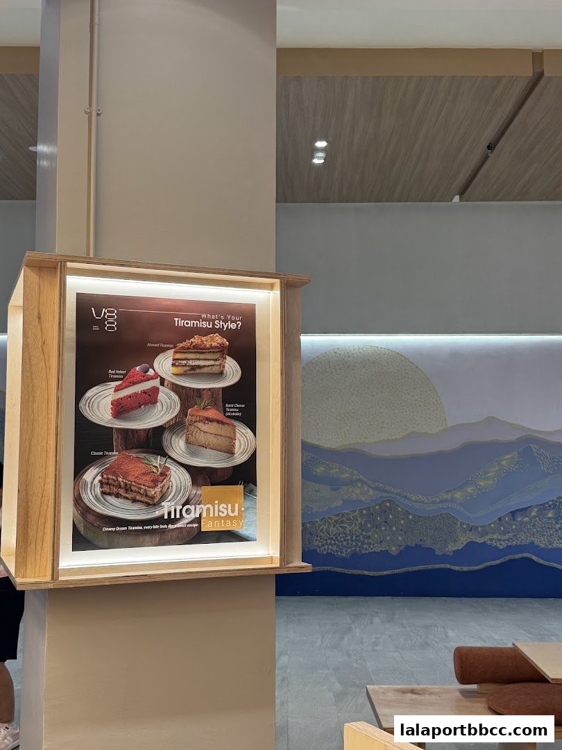 A display case showcasing various tiramisu desserts at V88 Cafe and Bar.