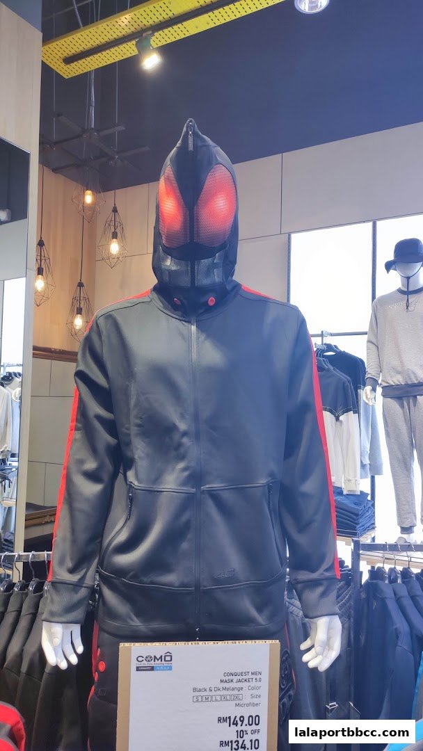 Mannequin wearing a black jacket with red accents and a distinctive mask.