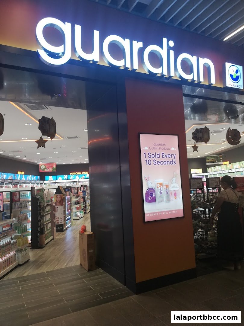 The entrance of a Guardian pharmacy and personal care store with illuminated signage.