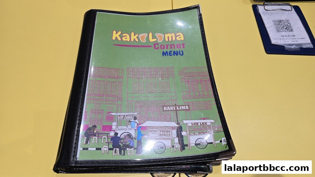 A menu for Kaki Lima Corner featuring street food stalls and traditional buildings.