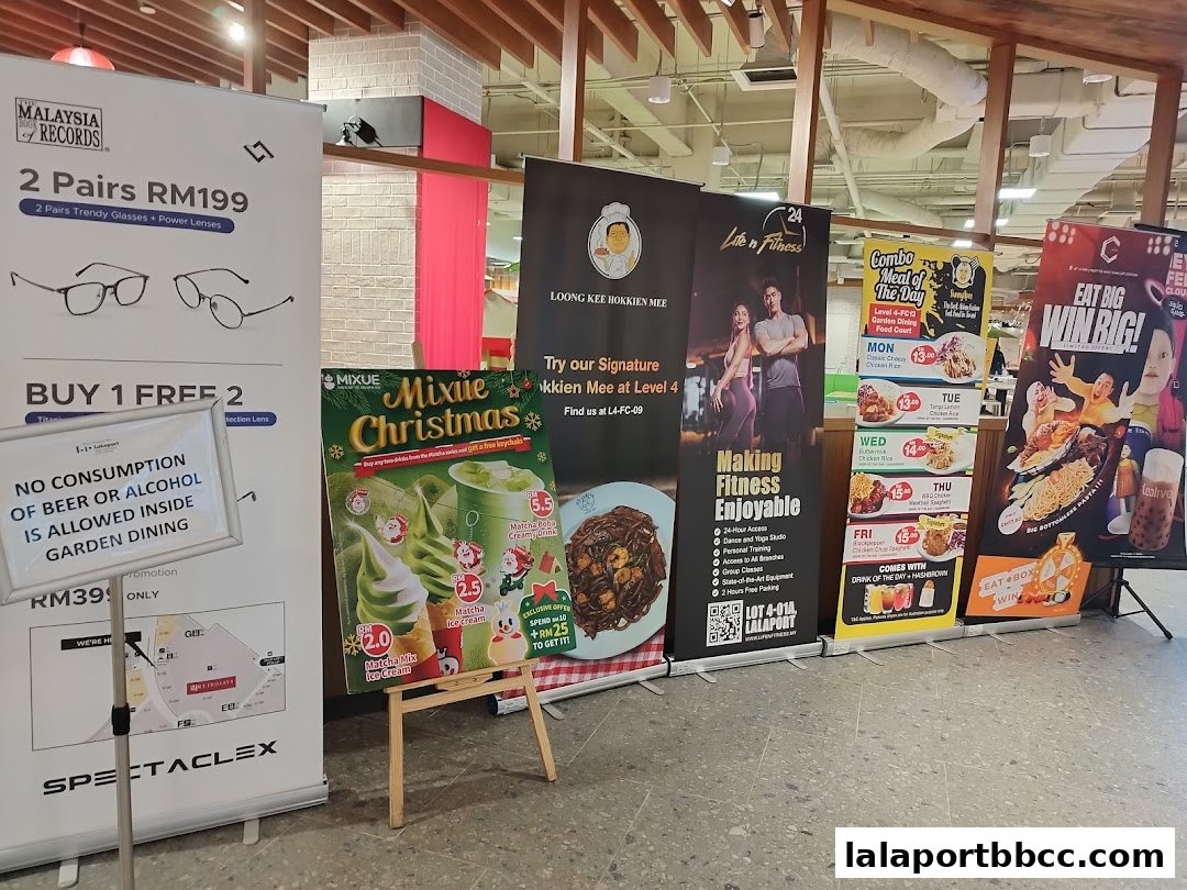 A row of promotional banners and signs displayed in a food court area.