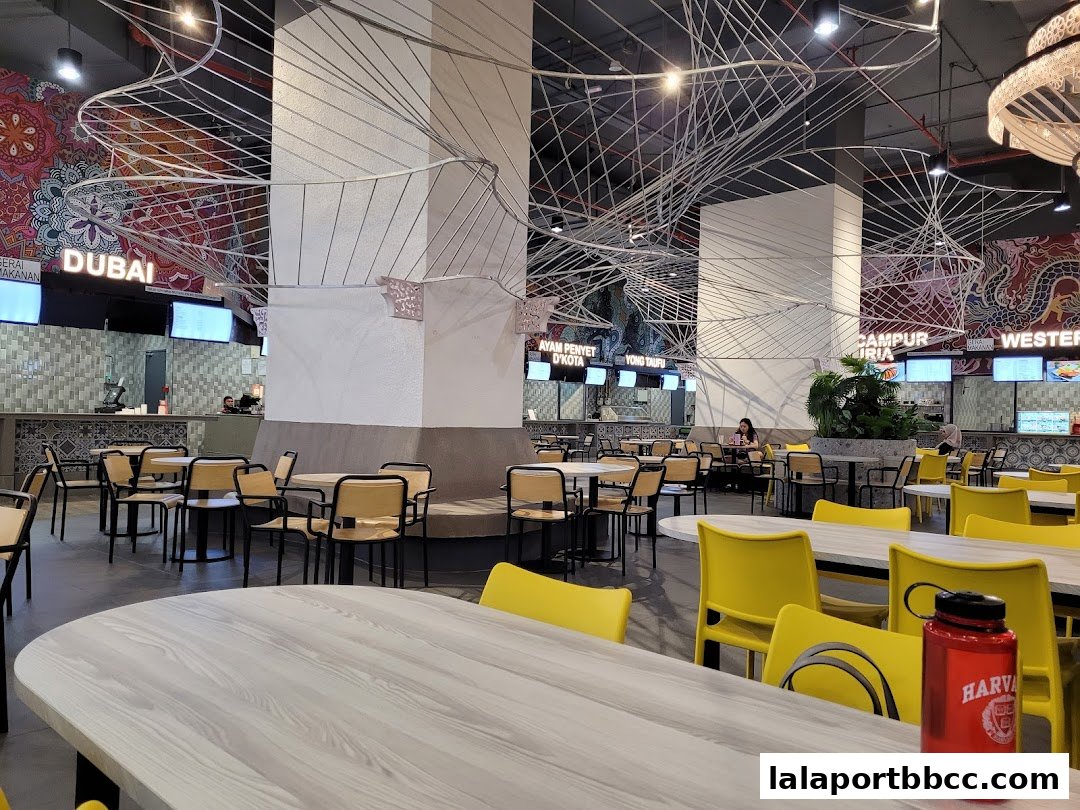 A spacious food court with various dining stalls and seating areas.