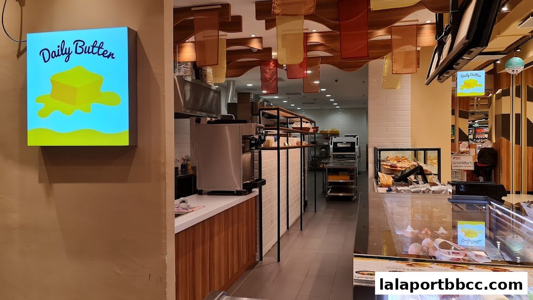 Interior view of a bakery with a prominent 'Daily Butter' sign and display cases.