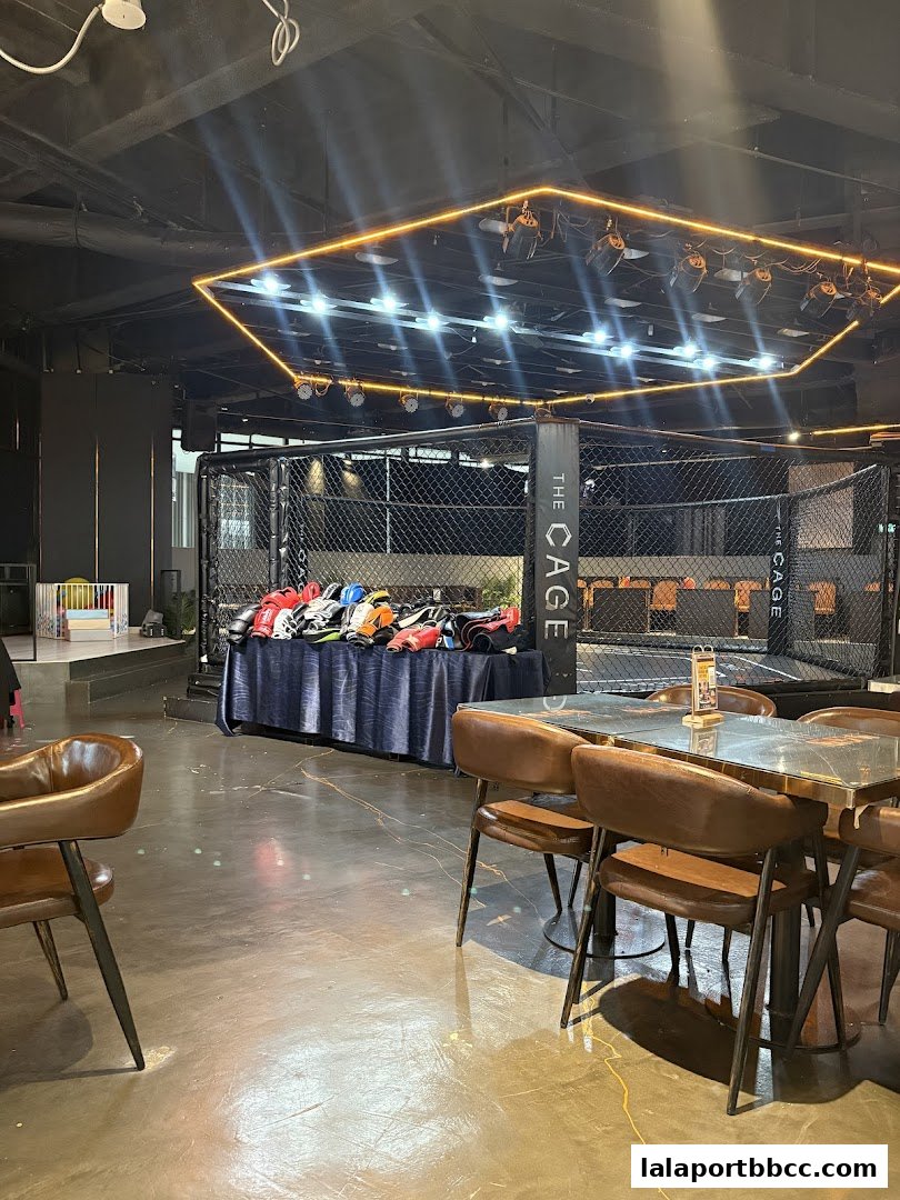 Interior of The CAGE - Duel Dine, featuring a boxing ring and seating area.