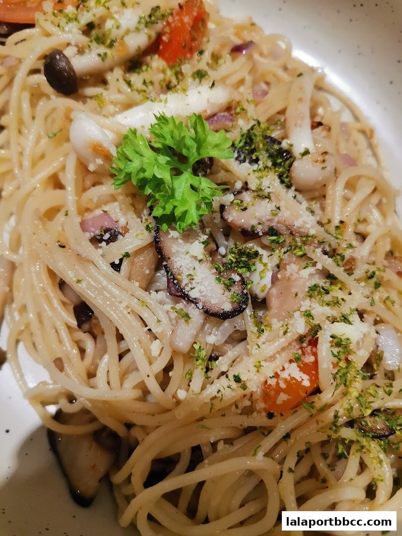 A close-up shot of a delicious pasta dish with seafood, mushrooms, and herbs.