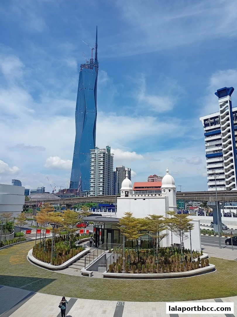 A modern building with a distinctive twisted skyscraper in the background.