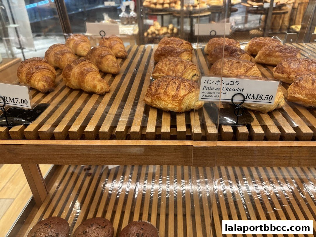 A display of freshly baked croissants and pain au chocolat at a bakery.