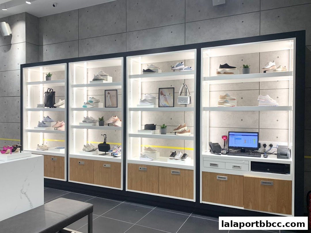 Interior view of a Cole Haan store showcasing various footwear and handbags on illuminated shelves.
