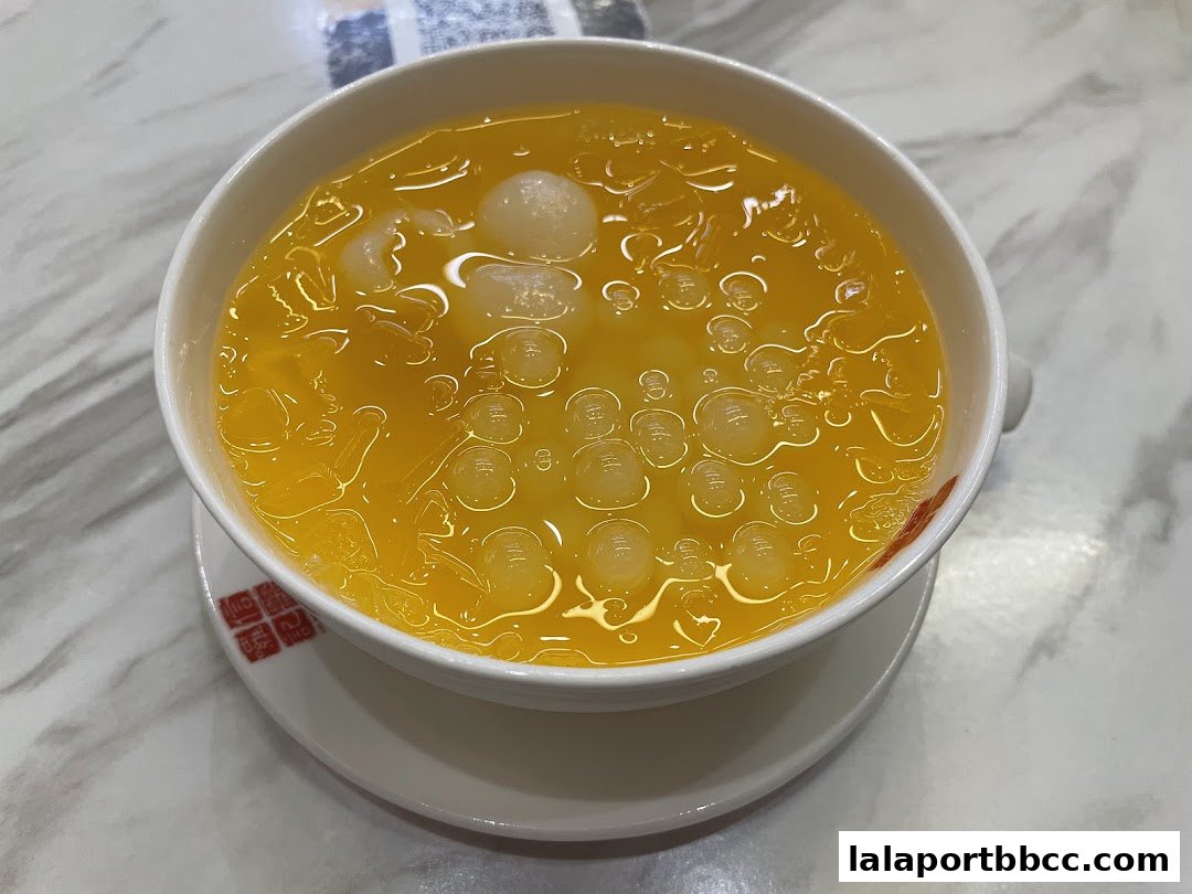A close-up shot of a refreshing yellow dessert with ice and tapioca pearls.