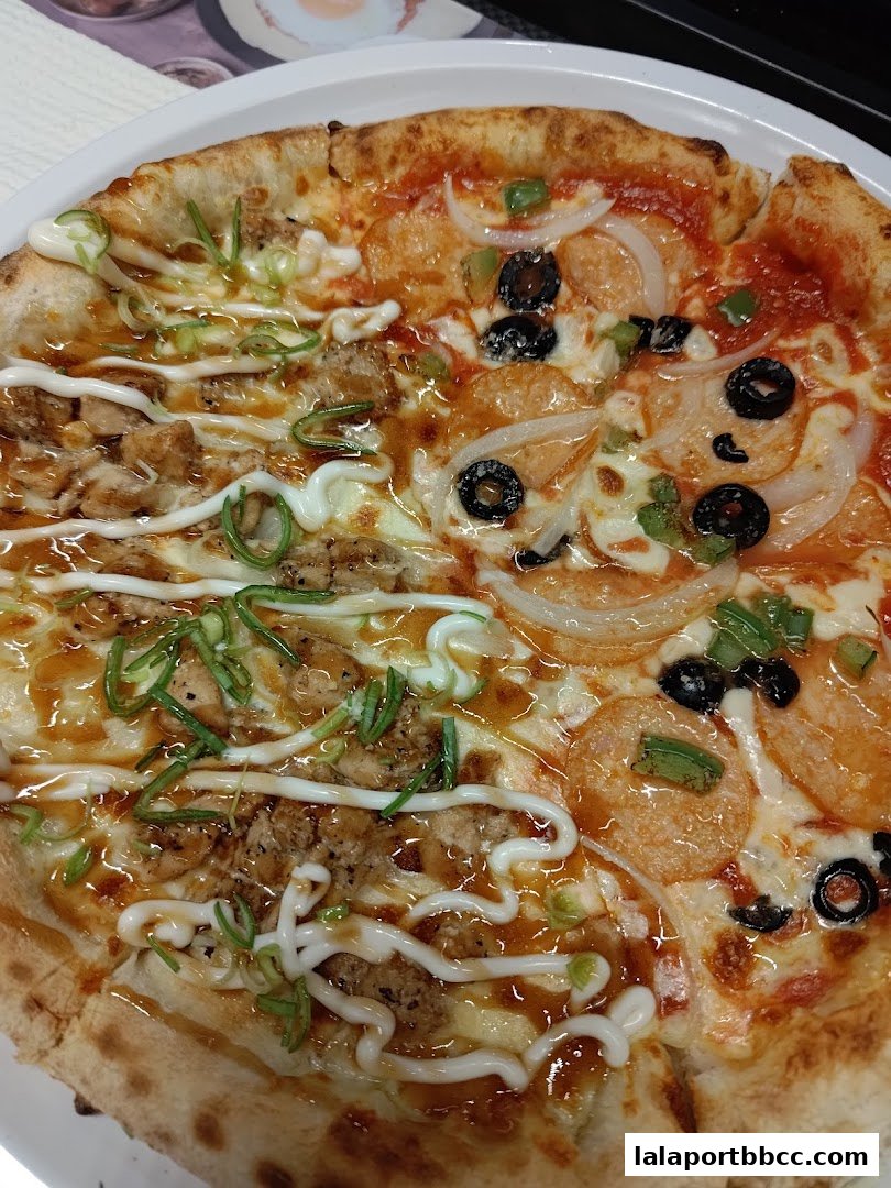 A close-up shot of a delicious pizza with two distinct halves, one with chicken and sauce, the other with pepperoni and olives.