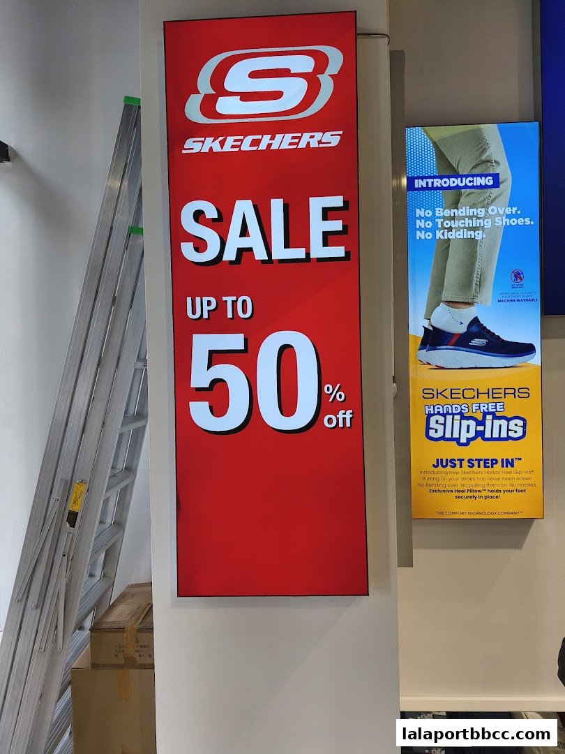 Skechers store sign advertising a sale up to 50% off and new Hands Free Slip-ins.