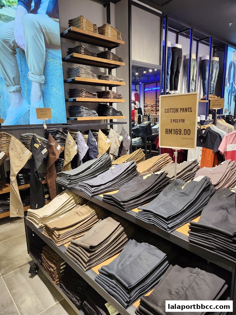 A well-organized display of folded cotton pants in various neutral colors at the Dapper store.