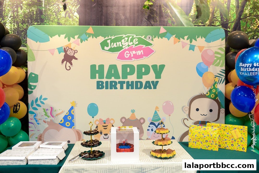 A birthday party setup with a jungle theme, featuring balloons, cake, and gifts.