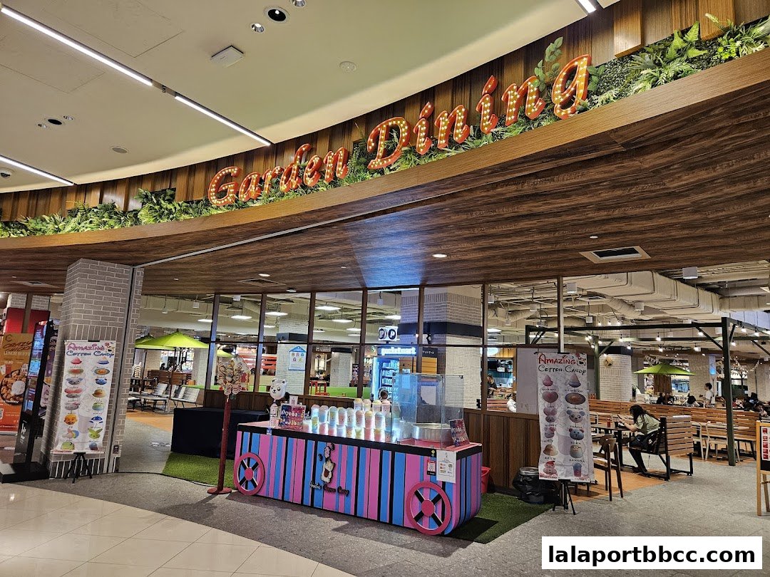 A food court with a 'Garden Dining' sign, seating areas, and various food stalls.