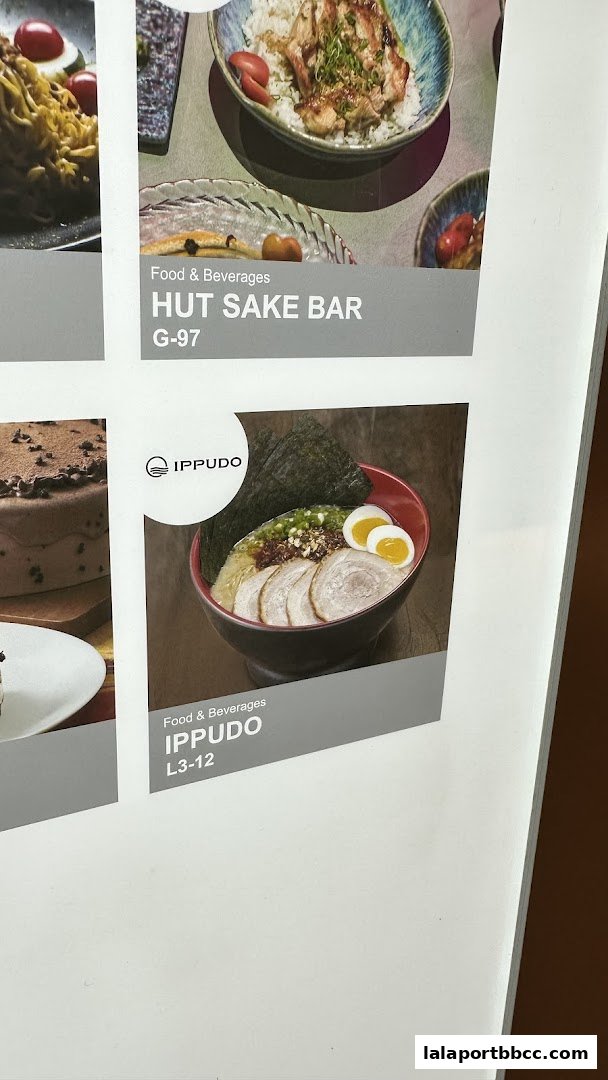 A display board featuring food and beverage offerings from IPPUDO and HUT SAKE BAR.