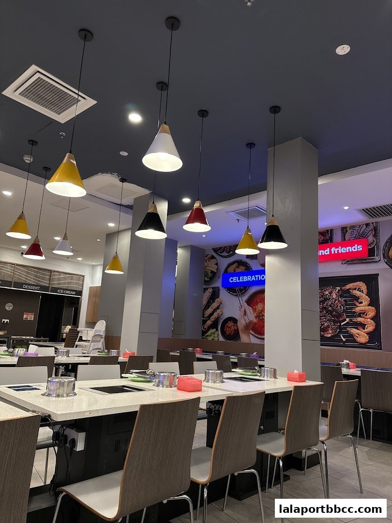 Interior of a modern restaurant with tables set for dining and colorful pendant lights.
