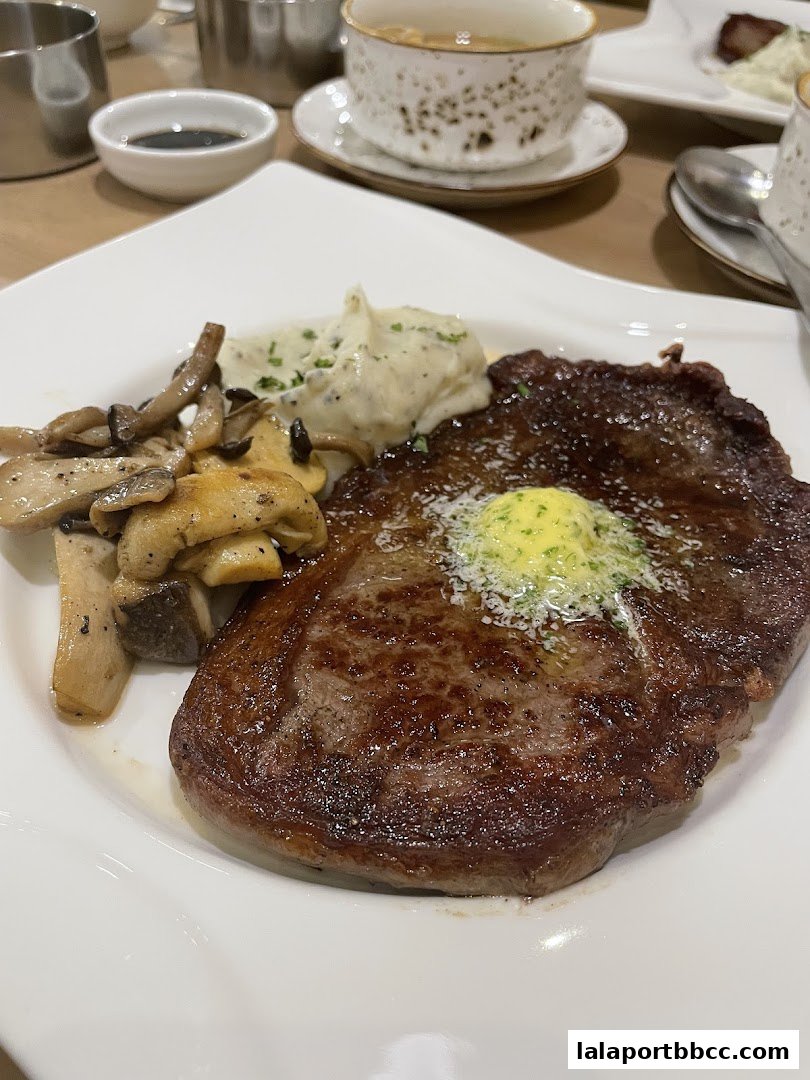 A perfectly cooked steak with mashed potatoes and mushrooms, served on a white plate.