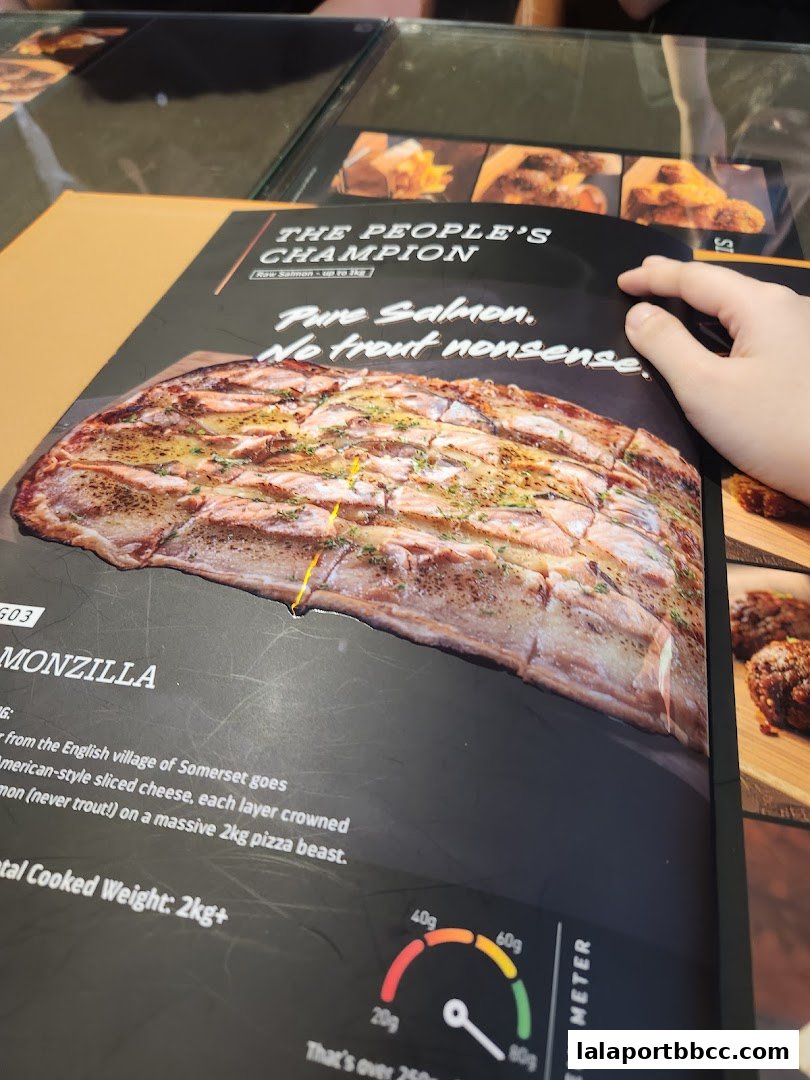 A menu item called 'MONZILLA' featuring pure salmon pizza with a description and weight.